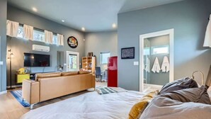 A modern bedroom with a large bed, a sofa, a TV, and a wardrobe. - Holly Studio walkable to Downtown, bars, SXSW (Austin)