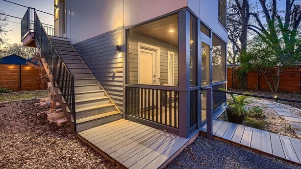 A modern house with a wooden deck, a staircase, and a glass door leading to a covered porch. - Holly Studio walkable to Downtown, bars, SXSW (Austin)