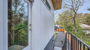 A modern building with a glass door leading to a balcony overlooking a garden. - Holly Studio walkable to Downtown, bars, SXSW (Austin)