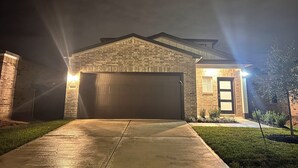 A residential garage with a brick facade and a large garage door. - The Gathering Lovely Spacious 5-bedroom House  (Magnolia)