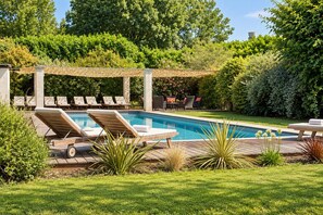 A pool area with lounge chairs, a pergola, and a well-maintained lawn. - Luxurious residence for 30 people, with a pool and a large garden (Garrevaques)