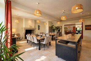 A spacious dining area with a long table, multiple chairs, and hanging wicker pendant lights. - Luxurious residence for 30 people, with a pool and a large garden (Garrevaques)