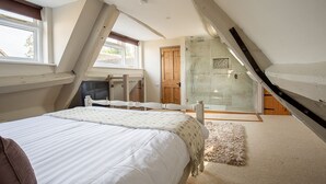Ein Schlafzimmer mit Bett, Fenster, Tür und Duschbereich.
