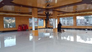 A spacious room with a polished floor, large windows, and wooden paneling. - Mount View Dhanaulti Dreams (Dhanaulti)