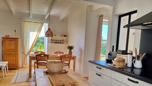 A modern kitchen with wooden furniture, a dining table, and a black countertop.