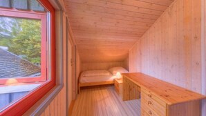 A small, wooden cabin room with a single bed, a nightstand, and a window. - Ferienhaus im Ferienpark Mirow (Mirow)