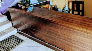 Un escalier avec une rampe en bois menant à un palier où se trouvent un ordinateur et divers objets.