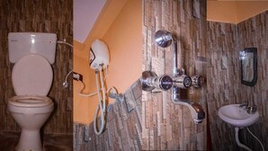 Une salle de bain avec des toilettes, une douche et un lavabo.