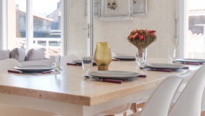 A dining table set with plates, cutlery, and a vase with flowers. - Beautiful 6-person apartment - Arago District (Les Sables-d´Olonne)