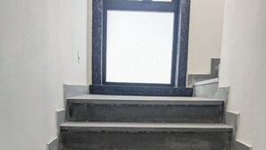 A set of concrete stairs leading up to a window with a black frame. - MAHA RAAS A Unit of RAAS LEELA Hotel  (Udaipur)