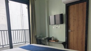 A hotel room with a bed, a desk, a chair, a television, and an air conditioning unit. - MAHA RAAS A Unit of RAAS LEELA Hotel  (Udaipur)