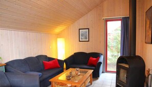 Um quarto acolhedor com sofá, mesa de centro, lareira e porta que dá para o exterior.