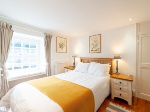 A bedroom with a bed, two bedside tables, a radiator, and two wall-mounted lamps. - Beautiful private villa for 6 guests with WIFI, TV, patio and pets allowed (Portloe)