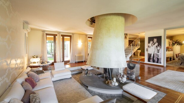A spacious living room with a large round table, a sofa set, and a staircase leading to another level. - Wonderful private villa for 10 people with WIFI, hot tub, private pool, A/C and panoramic view (Terranuova Bracciolini)