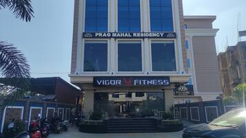 Un edificio con un cartel que indica 'Prag Mahal Residency' y 'Vigor Fitness'.