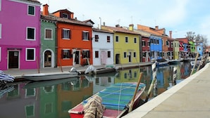 A canal with colorful buildings and boats. - Belvilla by OYO Appartamento Rosso (Jesolo)