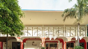 Een hotel met een tropische uitstraling, palmbomen en terrasplekken.