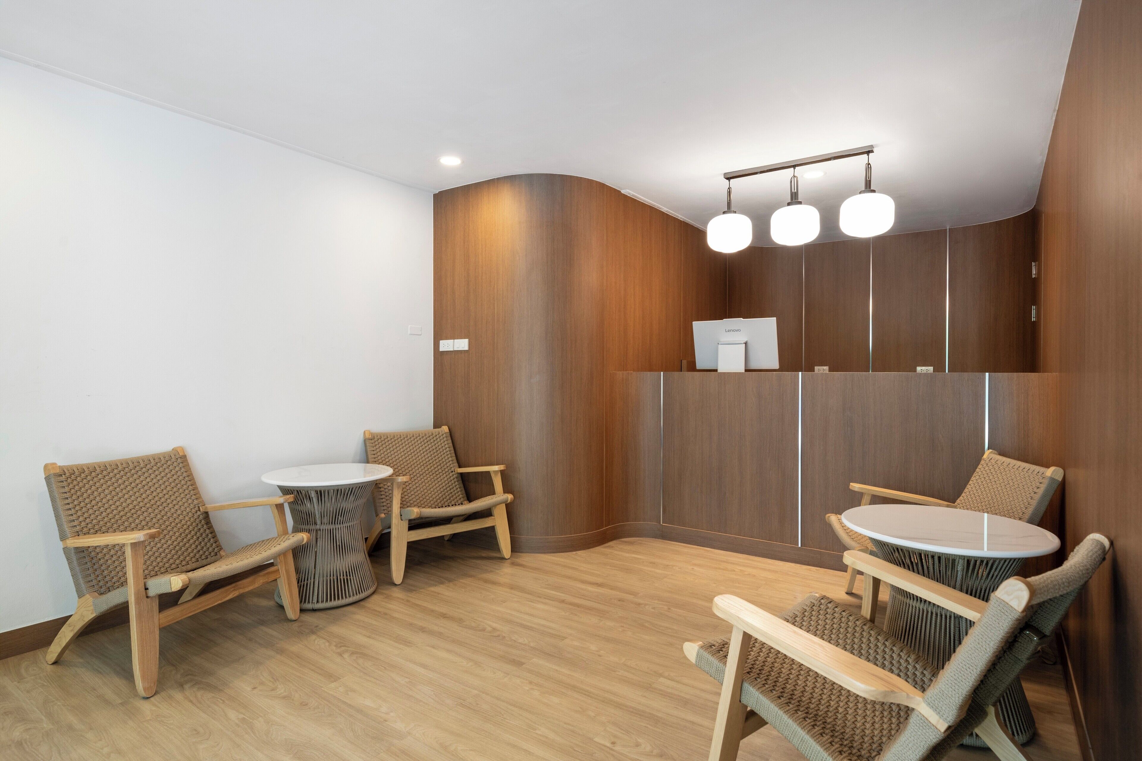 A modern, well-lit room with wooden furniture, including two round tables and four chairs, and a built-in wooden cabinet.