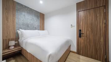 Un dormitorio moderno con estructura de cama de madera, pared de acento gris y armario de madera.