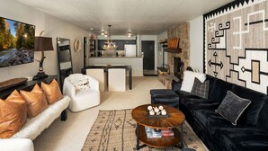 A modern living room with a sofa, coffee table, and a fireplace. - Villas at Snowmass Club - 1207 (Snowmass Village)