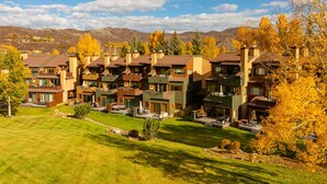 A residential area with modern houses, a well-maintained lawn, and autumn-colored trees. - Villas at Snowmass Club - 1207 (Snowmass Village)