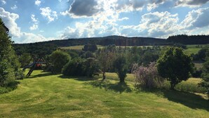Un campo cubierto de hierba con árboles y cielo despejado.