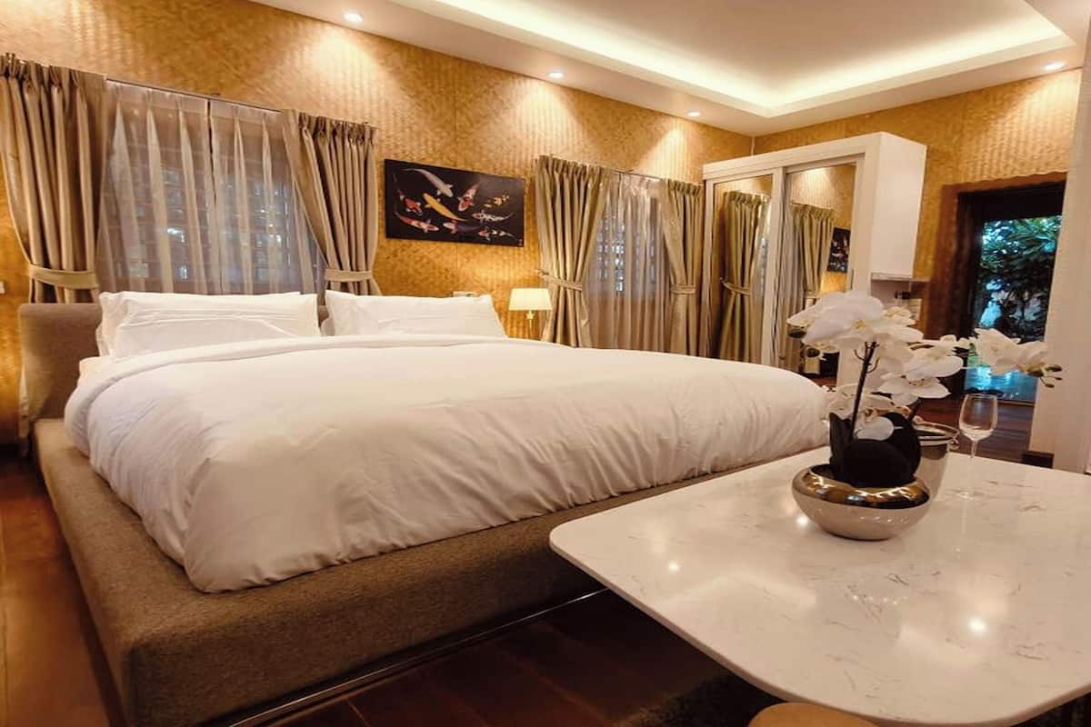 Ein Hotelzimmer mit einem großen Bett, einem kleinen Tisch und einem Spiegel.