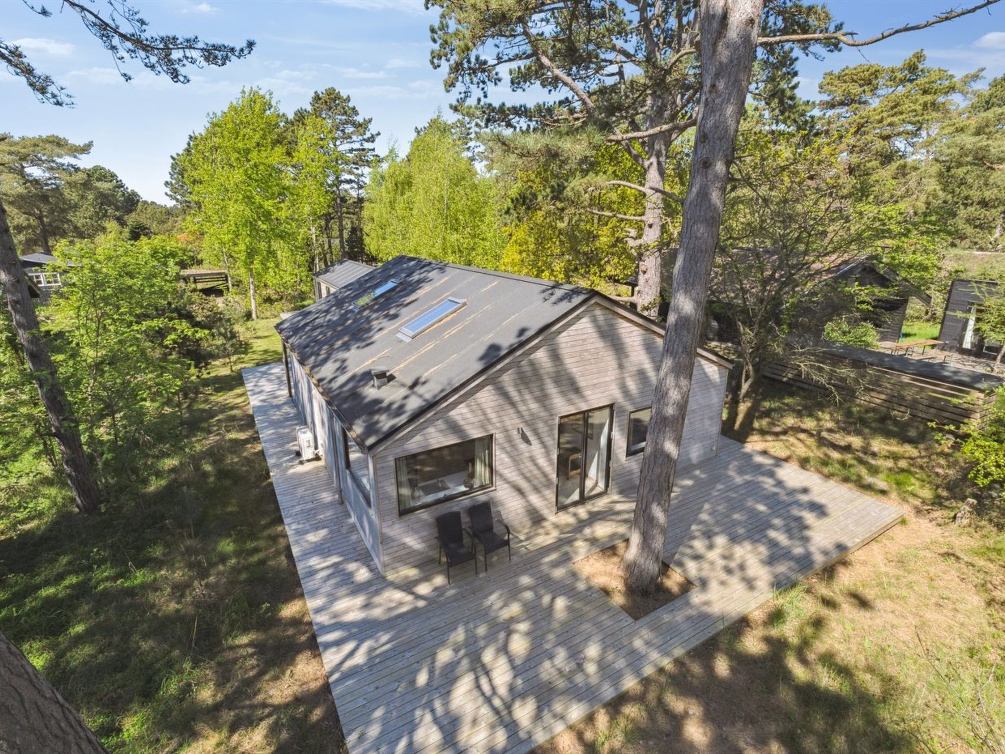 A single-story house with a sloped roof, large windows, and a deck.