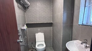 Un baño pequeño con inodoro, lavabo y ducha.