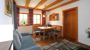 A cozy dining area with wooden furniture, a window with curtains, and a radiator. - Apartment in Fugen Near ski Resort (Fuegen)