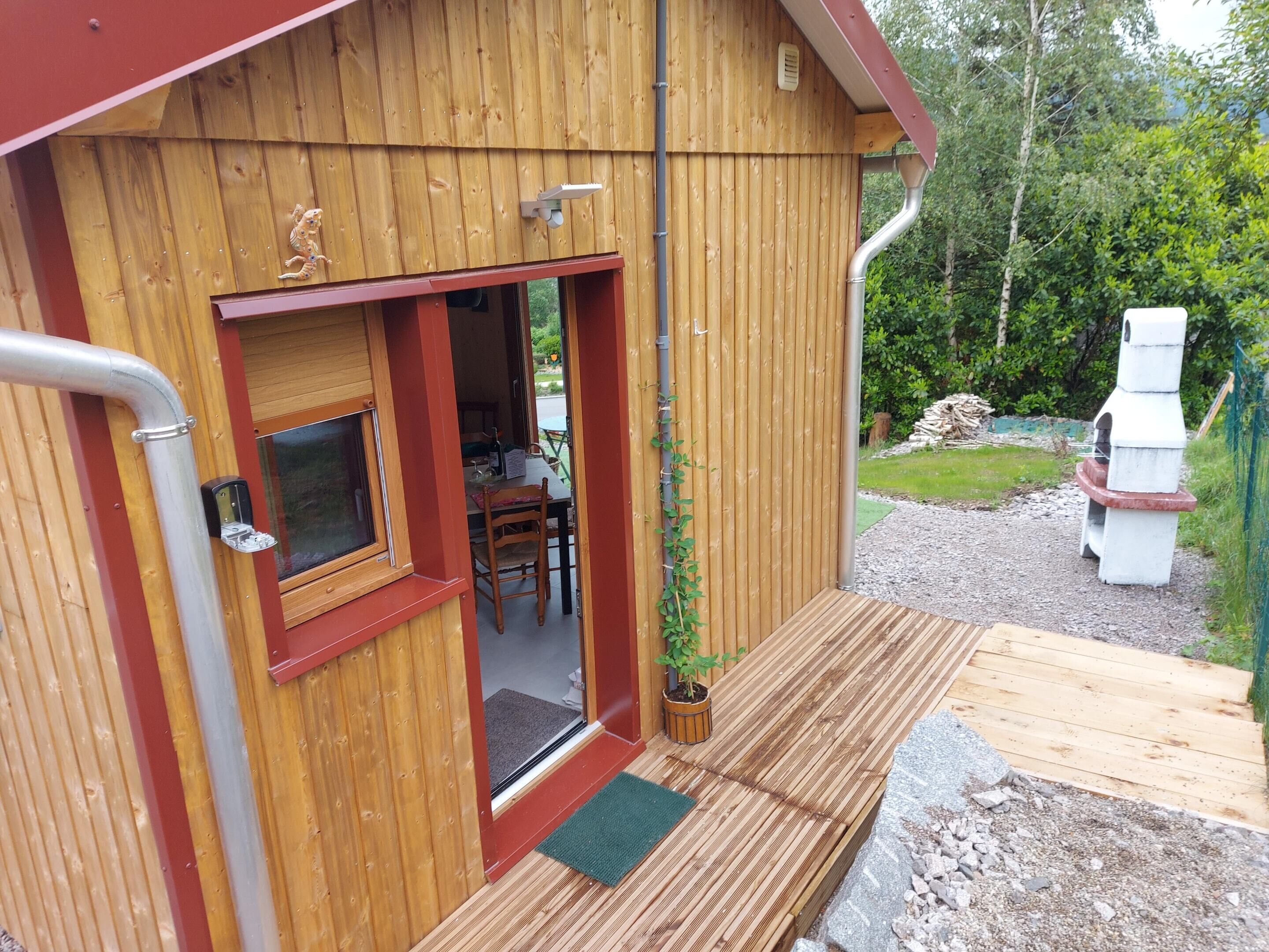 A wooden cabin with a dining area, a small window, and a door leading to the interior.