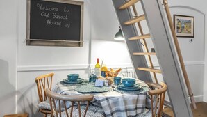 A dining table set with blue plates and a chalkboard sign reading "Welcome to Old School House."