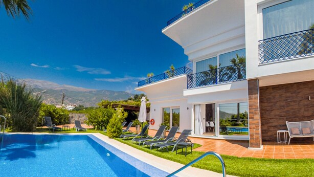 A modern hotel with a swimming pool, sun loungers, and a view of the mountains. - Los Nisperos de Paco (Canillas de Albaida)