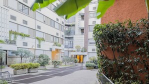 Een modern gebouw met meerdere verdiepingen, buiten zitplaatsen en groen.