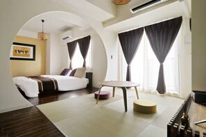 A modern hotel room with a bed, a round table, and a sofa. - Oyado RAKU (Osaka)