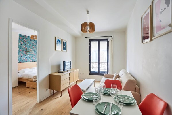 Un espacio habitable compacto con comedor, cama y kitchenette.