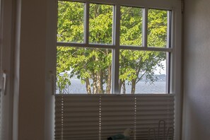 Enjoy a serene view of the water and surrounding trees from this room's window.