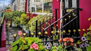 A hotel named "Hotel Rouge" with a prominent pink facade, large windows, and a staircase with golden balusters leading to the entrance. - Hotel Rouge (Blackpool)