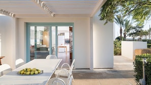 An outdoor patio with a table set for dining, a covered seating area, and a view of the interior kitchen and dining area. - Villa in Trapani With Private Pool & Near Sea (Paceco)