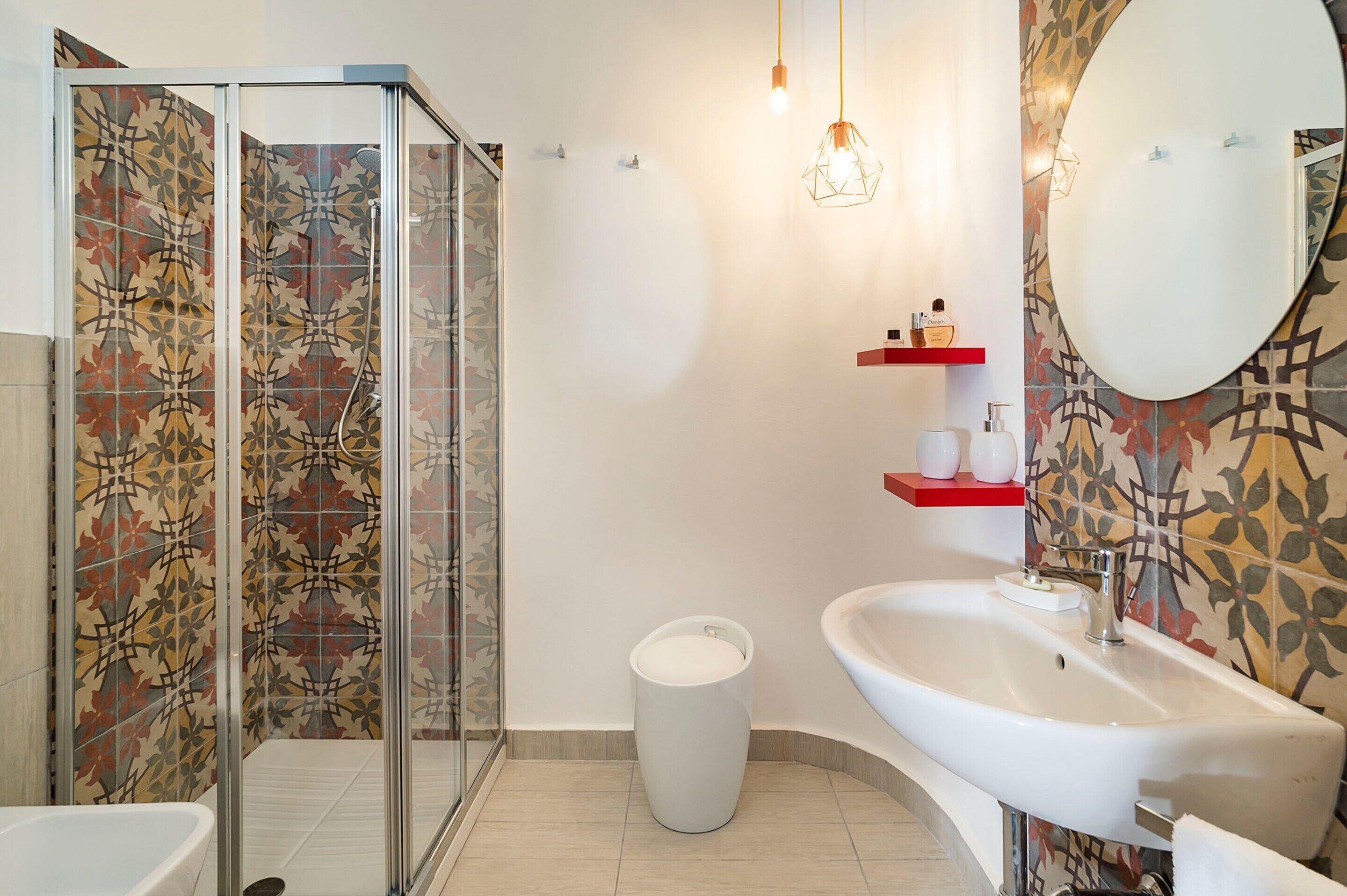 Un baño con ducha, lavabo y espejo.