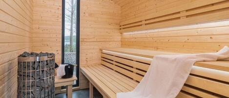 Un sauna avec des bancs en bois et un mur en pierre.