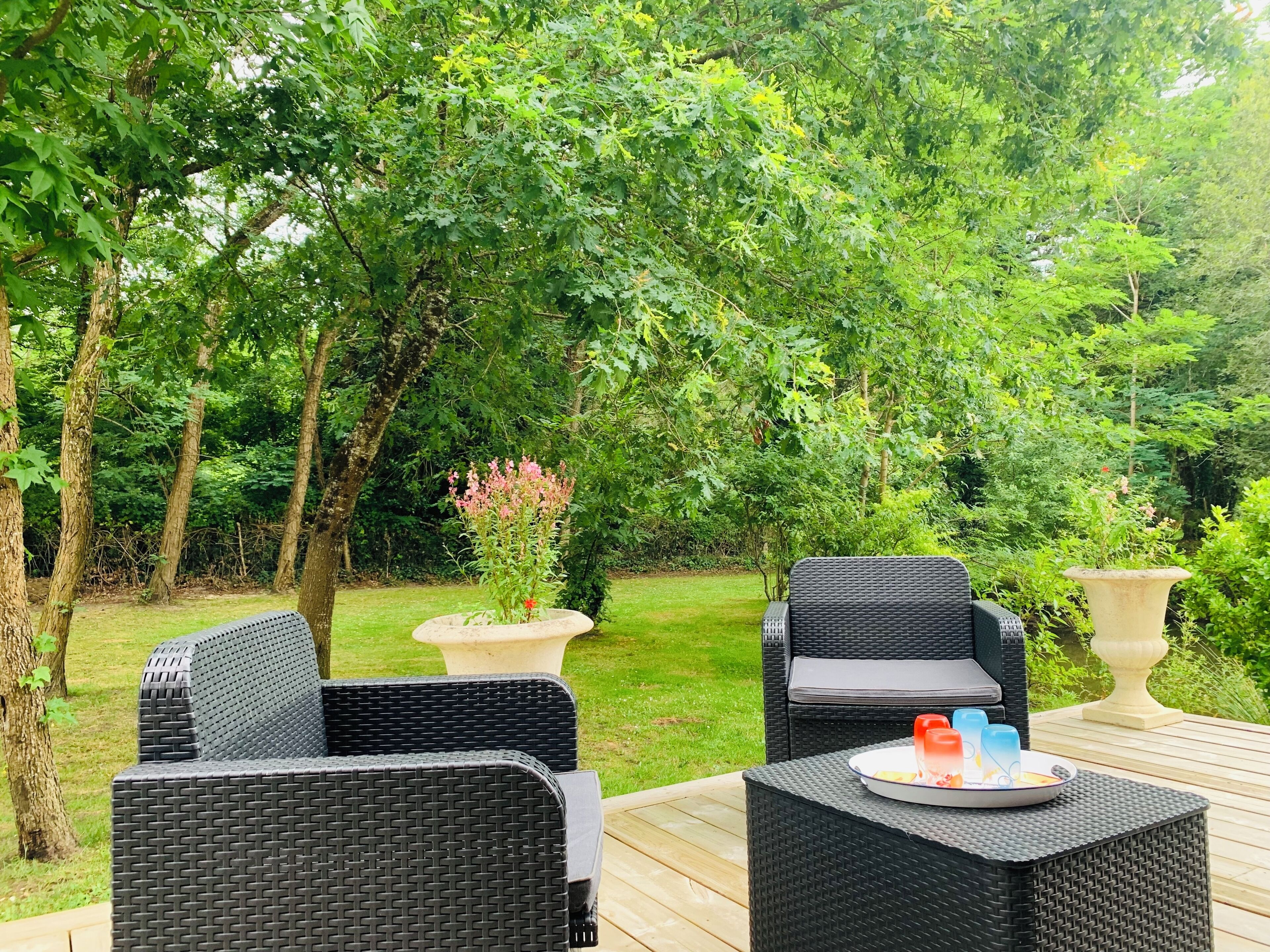 An outdoor seating area with wicker furniture and a fire feature.