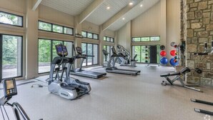 Ein geräumiges Fitnessstudio mit Laufbändern, Crosstrainern und Kurzhanteln.