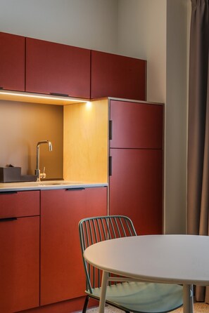 A compact kitchen with a single sink, a small table, and a chair. - Mooeve Psyri - Apartment One-bedroom (Athina)