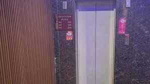 Et receptionsområde med receptionsdisk, skilt til receptionshallen, elevator og brandalarm.