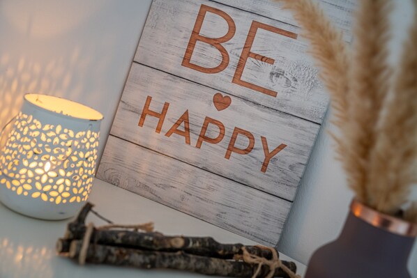 A wooden sign with the words "BE HAPPY" and a decorative lamp beside it. - Ferienwohnung in Busum (Büsum)