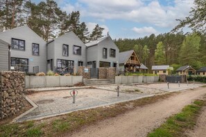 Un quartiere residenziale con diverse case, un muro in pietra e un vialetto lastricato.