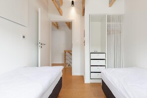 A hotel room with two beds, a wardrobe, and a door leading to a bathroom. - Holiday Home by Lake Wiselka With Sauna (gmina Wolin)