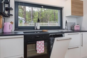 Una cucina moderna con finestra, lavello, piano cottura e lavastoviglie.