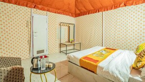 A room with a bed, a small table with a kettle, and a mirror. - Desert Stay Camping Jaisalmer (Jaisalmer)